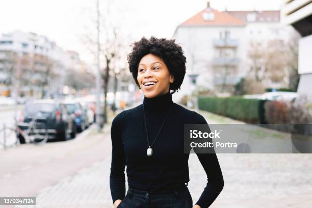 Portrait Of A Happy Young African American Woman Walking Down The City Street Stock Photo - Download Image Now