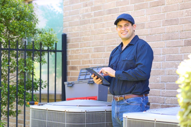 Latin descent young man, blue collar air conditioner repairman at work.