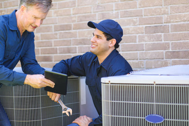 istock Multi-ethnic team of blue collar air conditioner repairmen at work. 1370347967