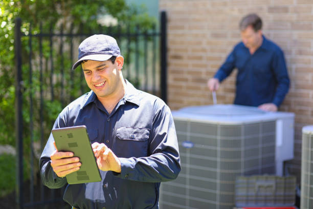 istock Multi-ethnic team of blue collar air conditioner repairmen at work. 1370347982
