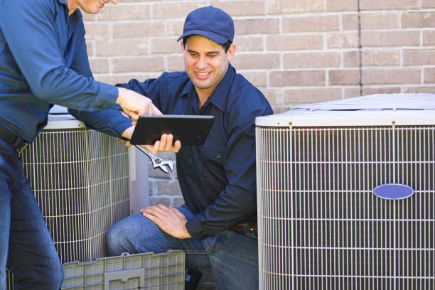 istock Multi-ethnic team of blue collar air conditioner repairmen at work. 1370347997
