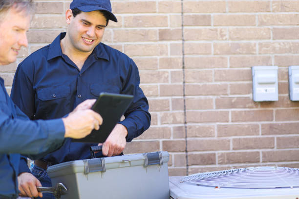 istock Multi-ethnic team of blue collar air conditioner repairmen at work. 1370348143