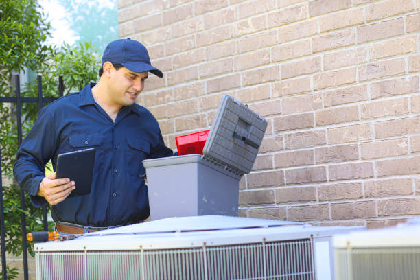istock Latin descent young man, blue collar air conditioner repairman at work. 1370348196