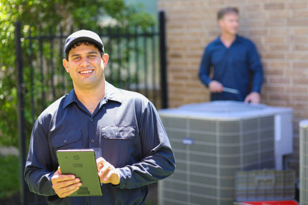 istock Multi-ethnic team of blue collar air conditioner repairmen at work. 1370348381