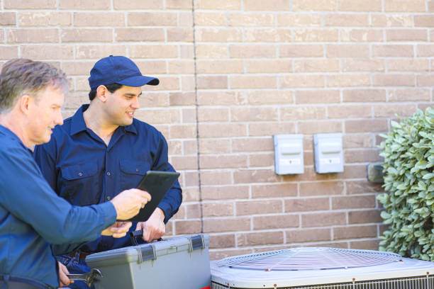 istock Multi-ethnic team of blue collar air conditioner repairmen at work. 1370348445