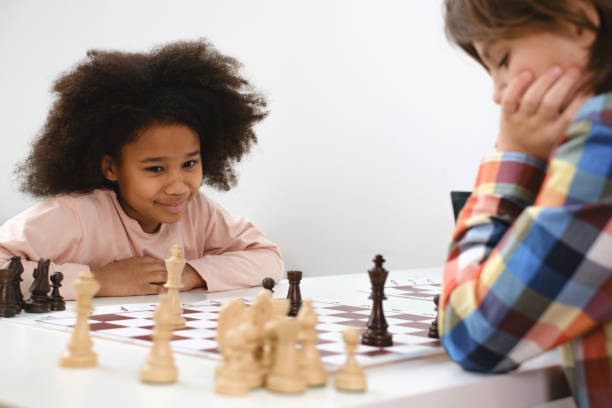 enfants multiethniques jouant à un jeu d’échecs à l’école - chess skill concentration intelligence photos et images de collection