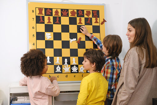 Child Thinking Hard On Chess Combinations on the wall on tournament for kids Intellectual game, hobby for children