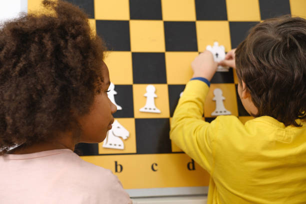 istock Chess board game tournament for kids closeup from back 1370351327