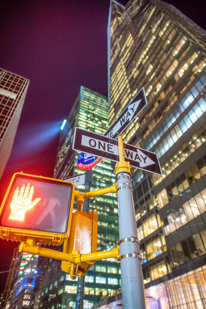 istock Pedestrian stop sign on a Midtown Manhattan traffic light at night. 1370352719
