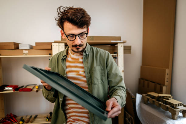 istock Handsome serious man holding metallic plate in workshop 1370353328