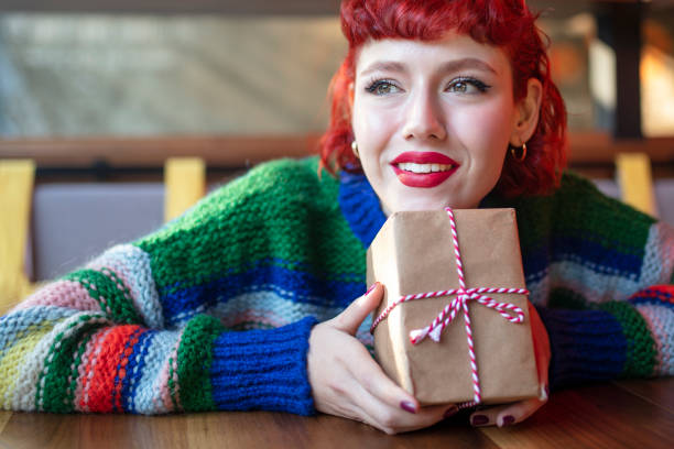 istock beautiful young woman holding gift box 1370354524