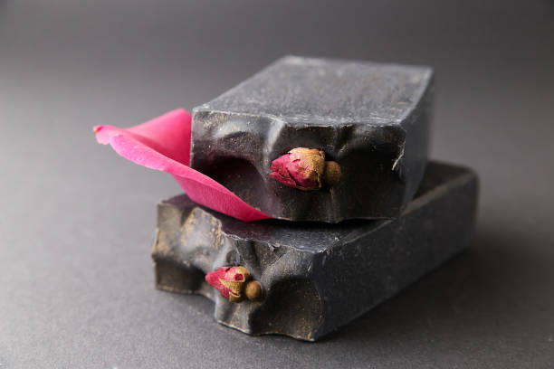 istock Soap natural handmade white,  with dry roses, on black background 1370356079