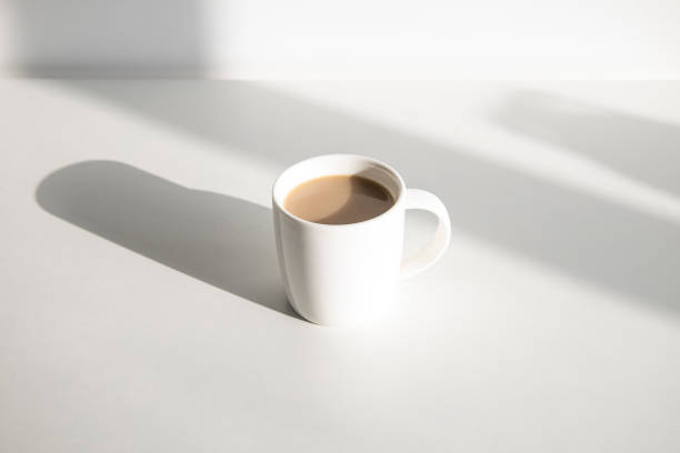 istock Coffee in a white cup on a white table under natural light. 1370357168