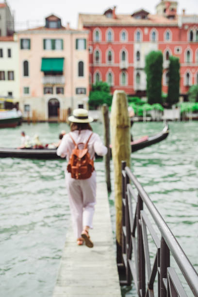 베니스에서 대운하를 바라보는 나무 부두를 걷고 있는 여성 - venice italy gondola grand canal luxury 뉴스 사진 이미지