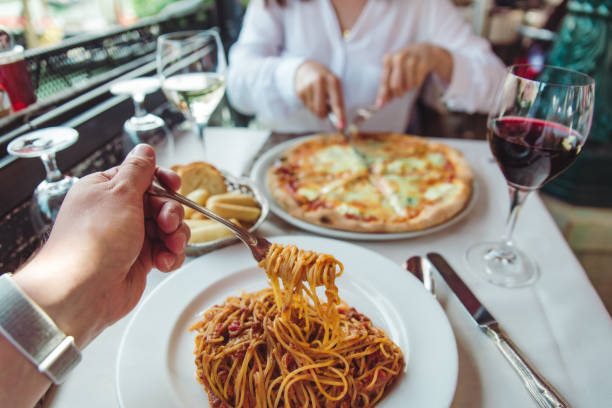 istock couple eating in restaurant pasta and pizza drinking wine 1370357309