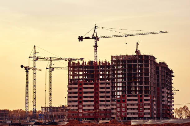 istock Construction site with frames of multistory buildings and cranes at blue sky background 1370357605