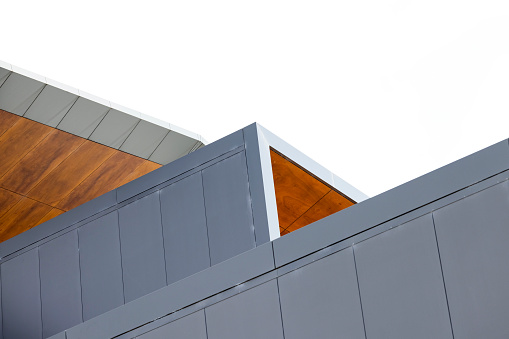 Closeup  detail of modern building, top part, white background with copy space, full frame horizontal composition