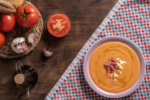 istock Round plate with salmorejo, ham and egg, along with some tomatoes, bread and garlic, ingredients used for its preparation. 1370363265