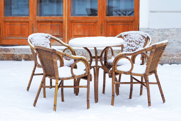 Old classical restaurant, rest area in winter. Table and basketry chairs covered snow