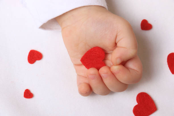 istock Baby Hand and Red Hearts 1370366698
