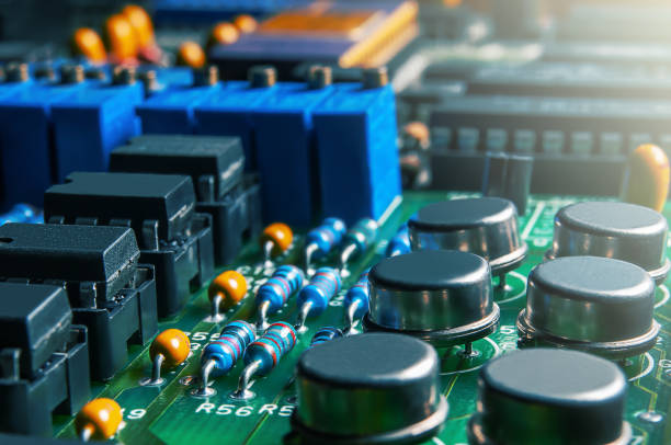 primer plano de la placa de circuito impreso con circuitos integrados y muchos otros componentes eléctricos pasivos. - condensador componente eléctrico fotografías e imágenes de stock
