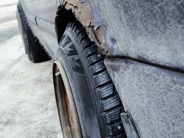 istock Banded custom wheels on rusty car. Mud and snow spiked winter tyres (studded tires). 1370370344