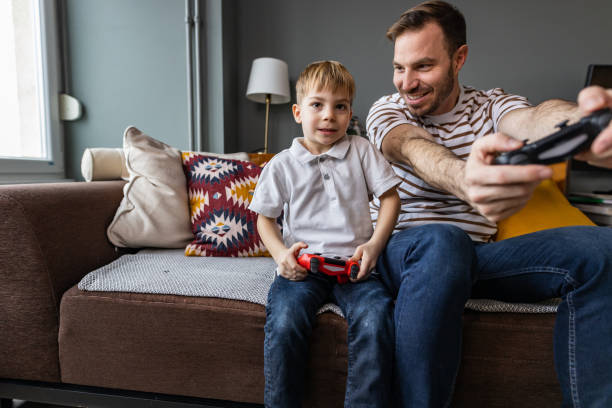 istock Young boy playing video games with his father 1370373647
