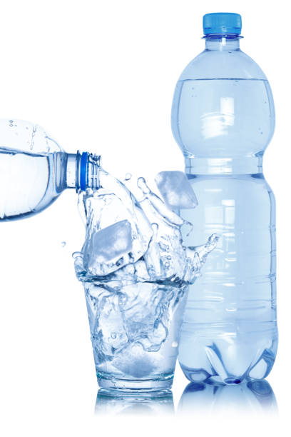 istock Water pouring into glass ice cube cubes bottle isolated on white 1370374799