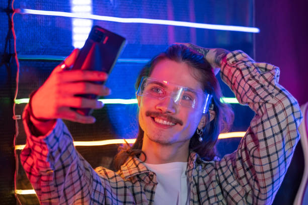 istock Man using smartphone and take selfie at night club with neon light 1370374880