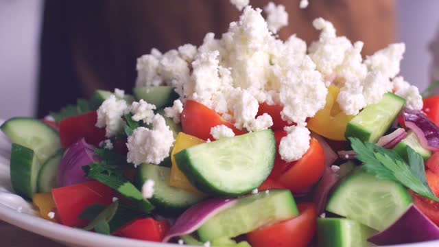 Feta cheese is thrown on the green salad.