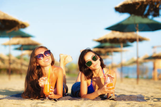 ragazze che si divertono su una spiaggia - umbrella beach sex symbol white foto e immagini stock