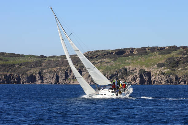 segelboote segeln bei windigem wetter im blauen wasser der ägäis - sailboat storm teamwork competition stock-fotos und bilder