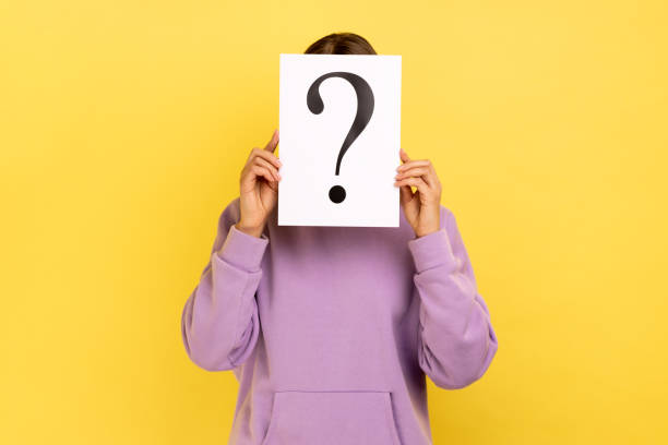 istock Woman hiding her face behind white paper with question mark, finding smart solution. 1370390807