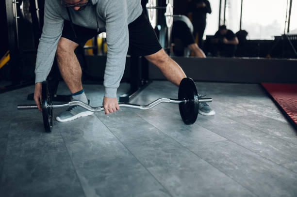 istock Middle aged man lifting barbell in the gym 1370391422