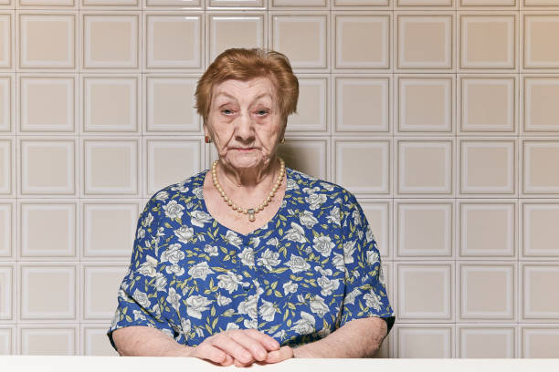 portrait of an old woman in the kitchen of her house. - 110 imagens e fotografias de stock