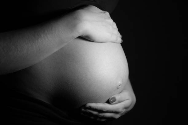 big pregnant belly, 9 month, 37 weeks pregnant, 3 trimester. in black underwear, on blue background. pregnancy.