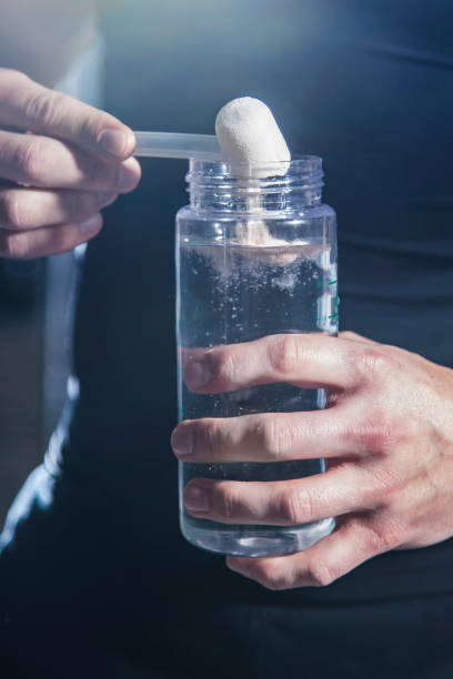 istock Pre Workout protein powder being poured into water bottle by athlete 1370398260