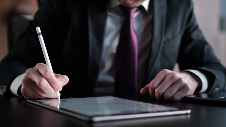 Businessman Signing Digital Contract On Tablet