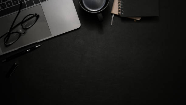 istock Modern office desk with laptop and copy space on black background. top view 1370409880
