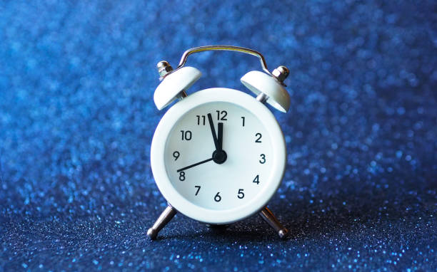 istock white alarm clock on a blue shiny background. 1370417676