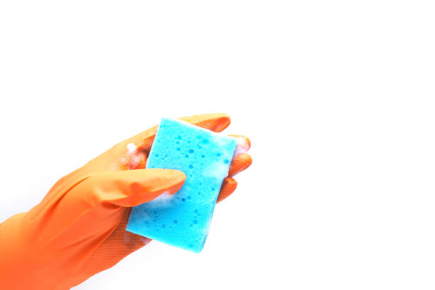 istock a hand in an orange rubber glove and a blue sponge with foam. isolate on white background. 1370417695
