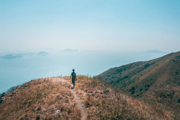backpacker hiker walking on mountain nearby the sea