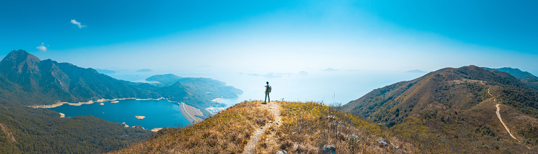 backpacker hiker standing on mountain nearby the sea