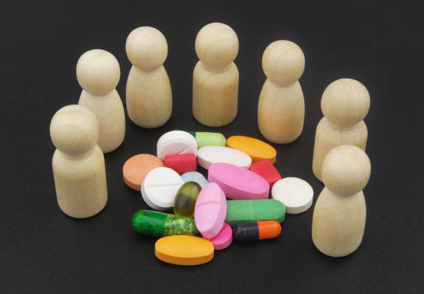 people figures with pills and drugs on black background - vibrant color healthcare and medicine healthy lifestyle vitamin pill imagens e fotografias de stock