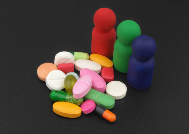 people figures with pills and drugs on black background - vibrant color healthcare and medicine healthy lifestyle vitamin pill imagens e fotografias de stock