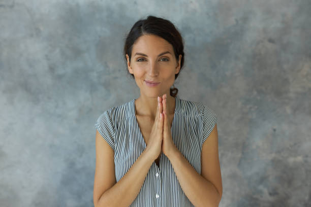 retrato de una mujer joven y astuta con ropa casual elegante frotándose las manos con una sonrisa engreída, lista para jugar trucos, hacer bromas a sus amigos. lenguaje corporal, emociones y sentimientos - smirking fotografías e imágenes de stock