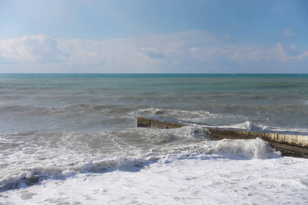 istock Dirty sea waves crash against the breakwater. 1370419955