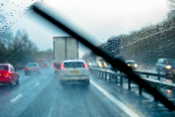 Adverse Driving Conditions Rain through the window of a car on a motorway windshield wiper stock pictures, royalty-free photos & images