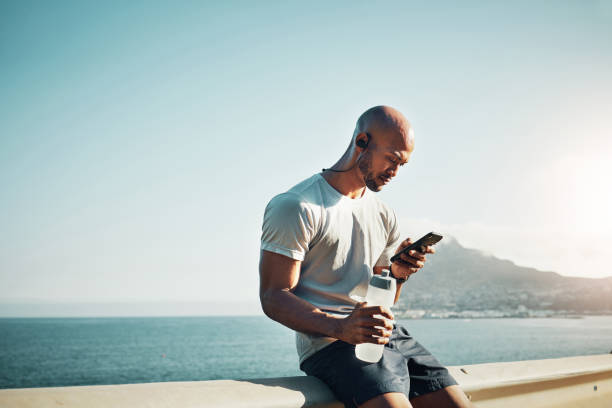 istock Shot of a young man sitting and using his phone outside 1370421129