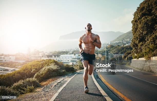 Shot Of A Sporty Young Man Running Outdoors Stock Photo - Download Image Now - Athlete, Running, Exercising